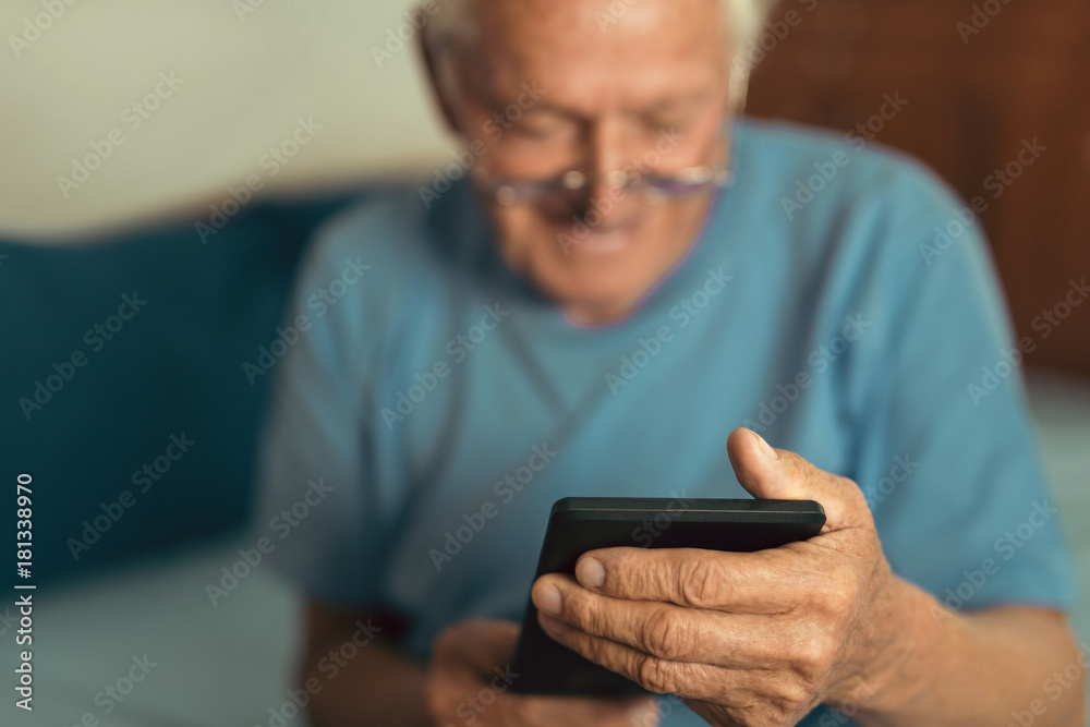 Senior man using digital tablet. Surprised mature male using portable computer at home