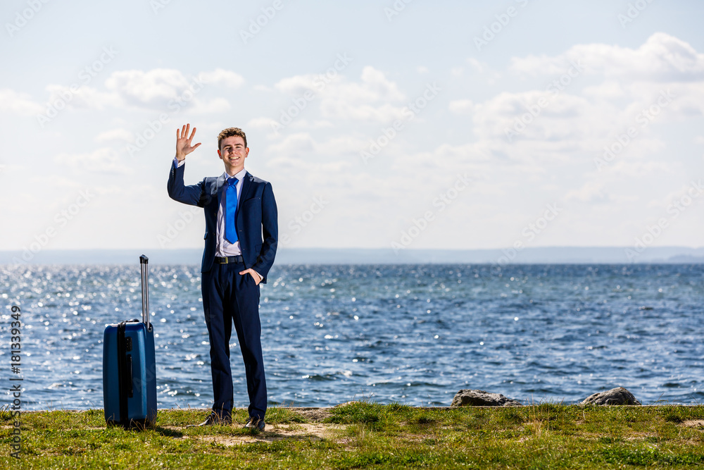 Businessman with suitcase standing at seaside Businessman with suitcase standing at seaside