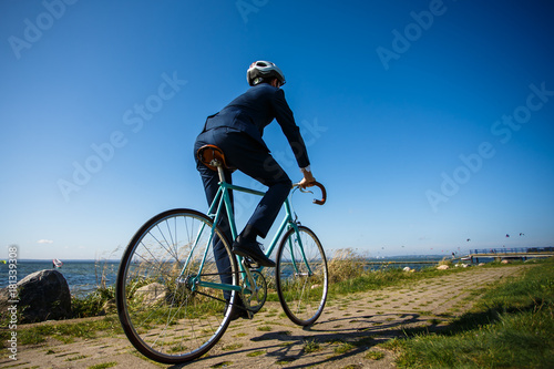Fototapeta Naklejka Na Ścianę i Meble -  Businessman cycling at seaside