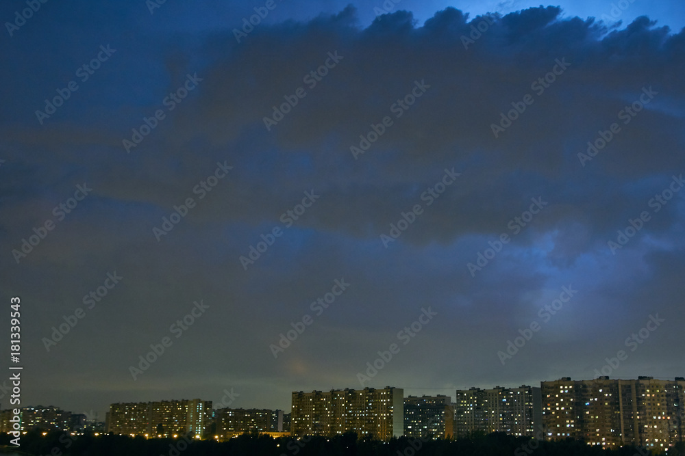 Cityscape at dusk with thunderstorm over apartments buildings