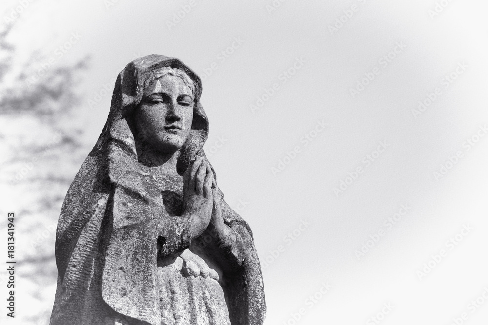 Virgin Mary statue. Vintage sculpture of sad woman in grief (Religion, faith, suffering, love concept)