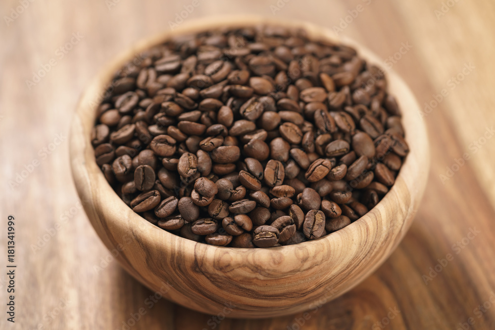 roasted coffee beans in wood bowl on table roasted coffee beans in wood bowl on table