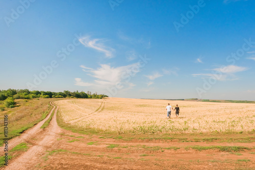 Young man and woman running on the yellow field