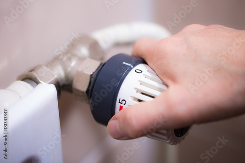 Das Thermostat an einem Heizkörper wird geschlossen