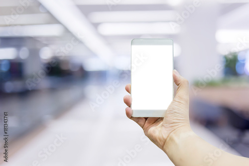 hand hold smartphone blank screen with blur image background of shopping mall