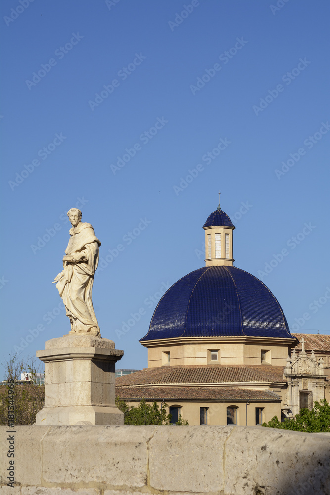 Estatua en el puente de la Trinidad y cúpula del museo de Bellas Artes. Valencia. España