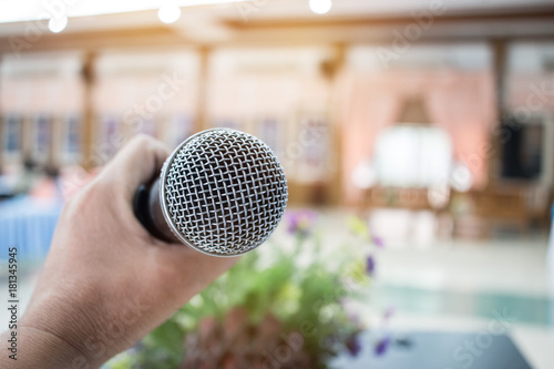 Microphone on abstract blurred of speech in seminar room or speaking conference hall light; computer bokeh background; Microphone on abstract blurred of speech in seminar room or speak;