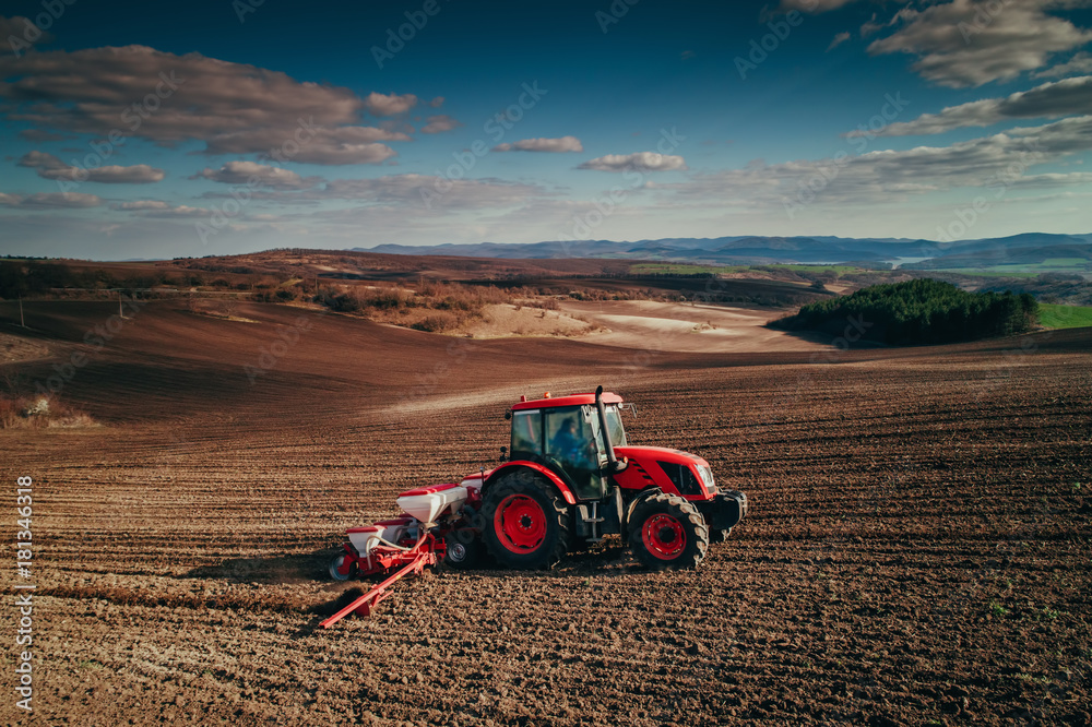 Naklejka premium Aerial view of tractors working on the harvest field