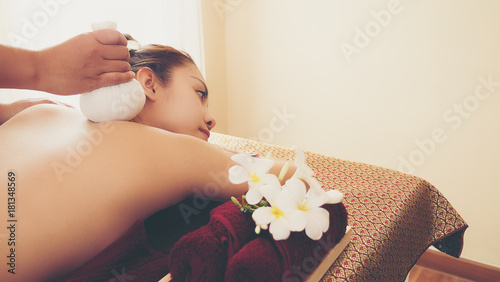 Selected focus on a massager's hand, taking massage on beautiful women, using herbal compress, women laying down on the bed. Thai massage. Massage is for relaxation and muscle pain relief.