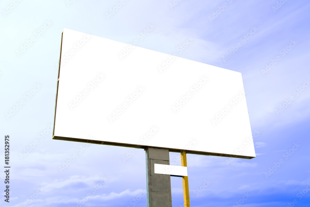 A large concrete billboard with a white screen against a blue sky on a sunny summer day. A large concrete billboard with a white screen against a blue sky on a sunny summer day.