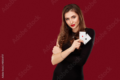 Beautiful caucasian woman in black dress with poker cards gambling in casino