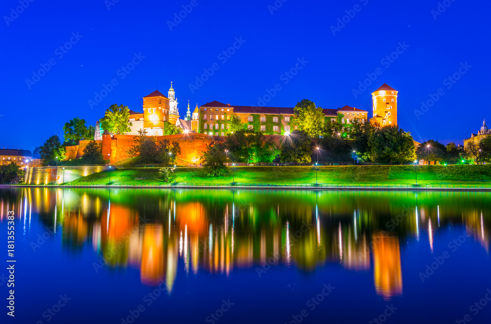 Fototapeta Oświetlony zamek na Wawelu w polskim mieście Kraków odbił się w nocy na Wiśle / Wiśle.