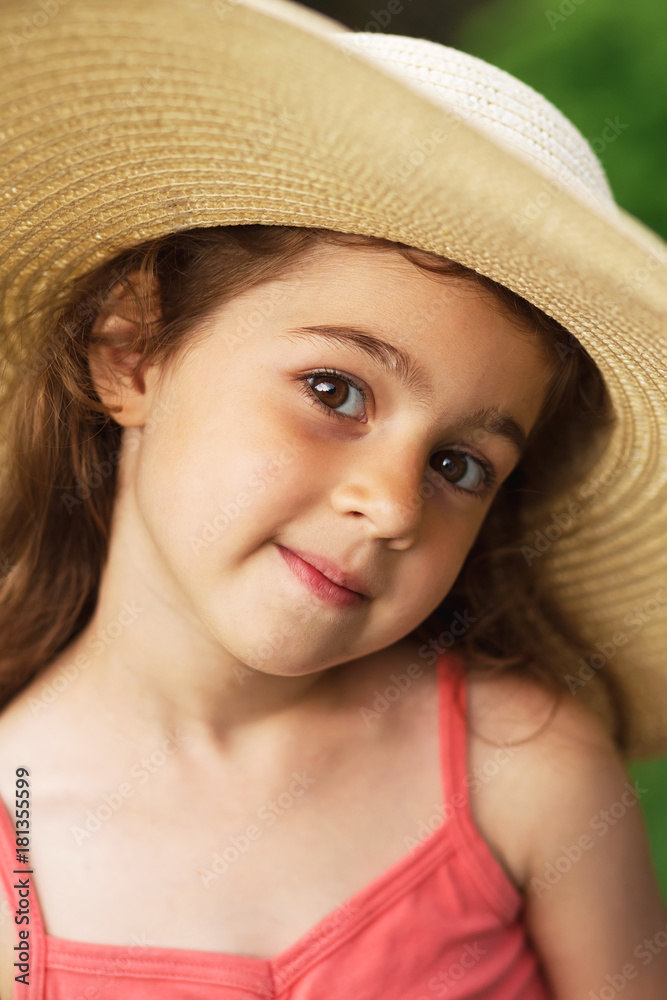 Portrait of smiling beautiful toddler in wide-brimmed hat at green of summer park. Portrait of smiling beautiful toddler in wide-brimmed hat at green of summer park.