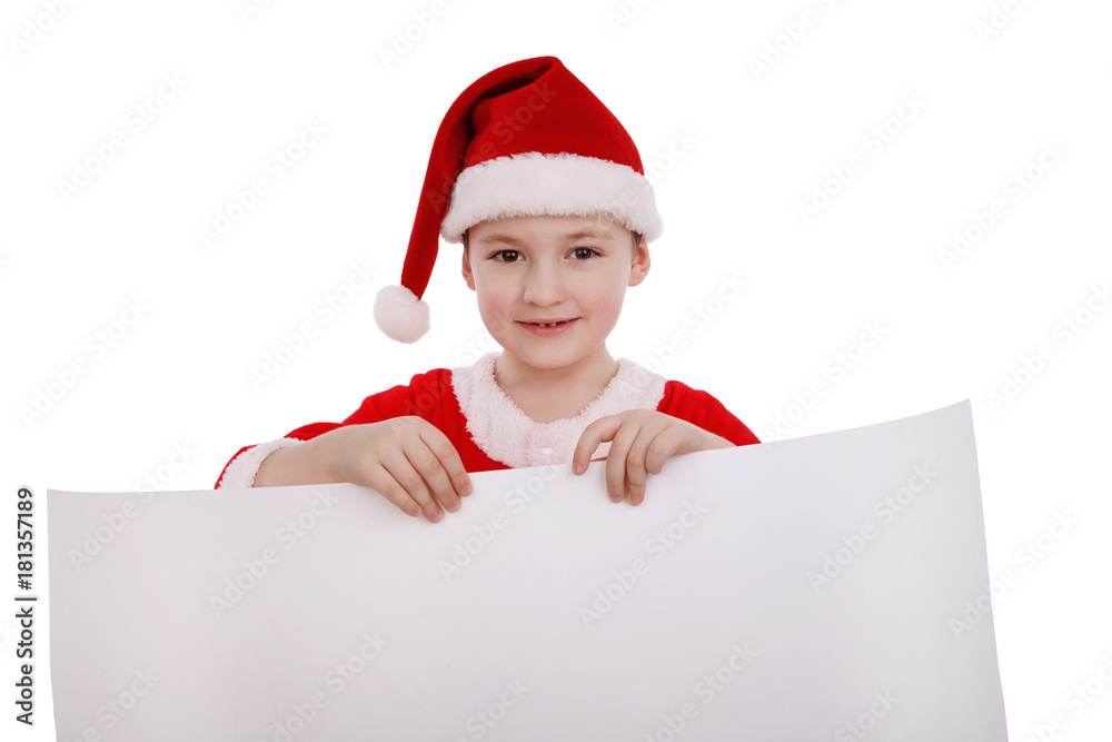 Boy in a suit of Santa Claus holds a white banner label isolated on white background Boy in a suit of Santa Claus holds a white banner label isolated on white background
