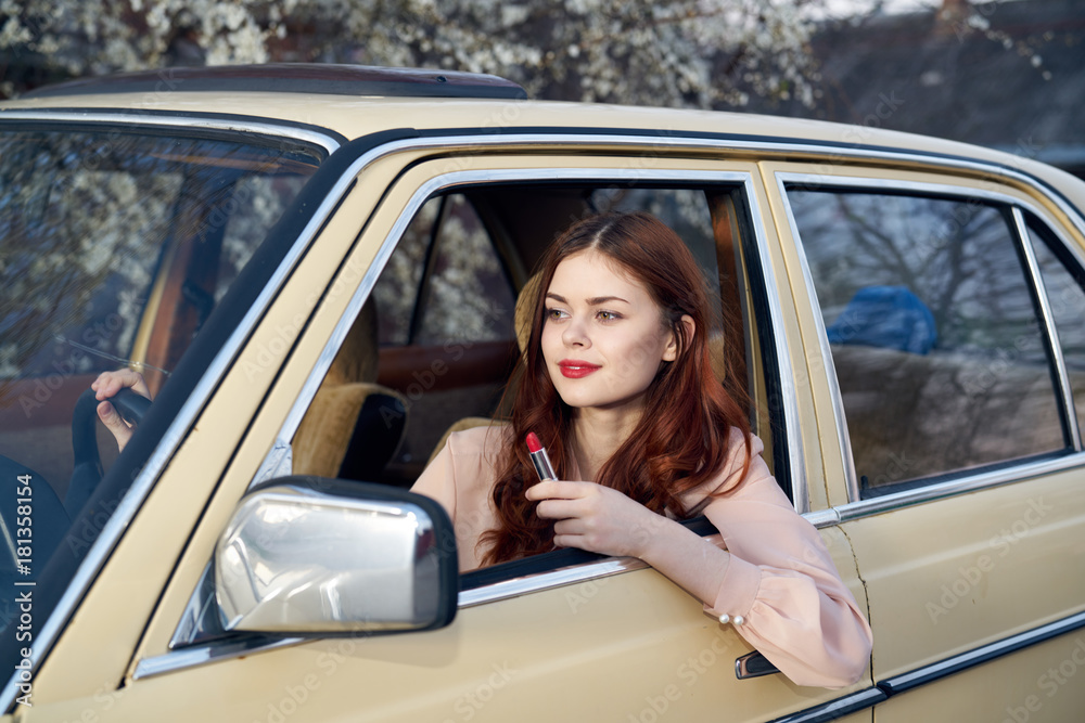 Beautiful young woman with red hair driving a car