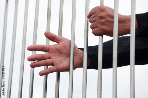 hand of prisoner in jail with white background.