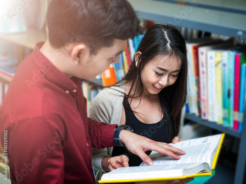 Asian university life concept. Young teenage student reading book in college library.Couple Student in the Library of College.Education Concept.In selective Focus