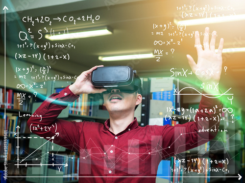 A beautiful young man in a library travels in a virtual futuristic world with augmented reality. Concept: educational, future, library, and immersive technology.