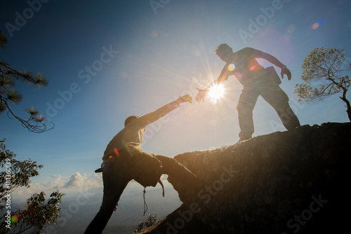 Man helping to climb the rock photo