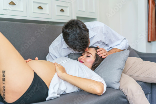 Handsome man kiss beautiful pregnant woman at living room. concept of pregnancy, family and lover relation. © bixpicture