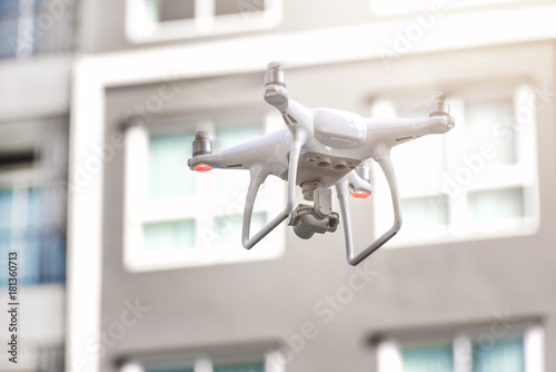 Modern RC Drone / Quadcopter with camera flying around building