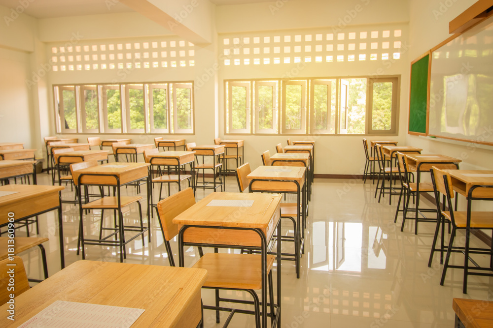 Obraz premium School empty classroom with test sheet or exams paper on desks chair wood and greenboard at high school thailand, education test concept