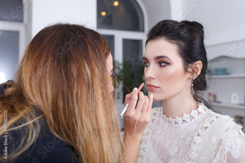 makeup artist applying lip contour with pencil