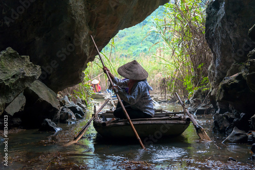 Bamboo boat tour in cave at Natural Reserve of Van Long wetlands in Ninh Binh, Vietnam photo