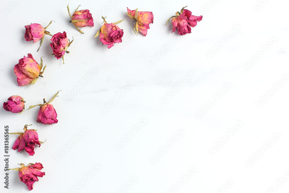 frame from dry roses on a marble background. simple flat lay composition. black space for a text