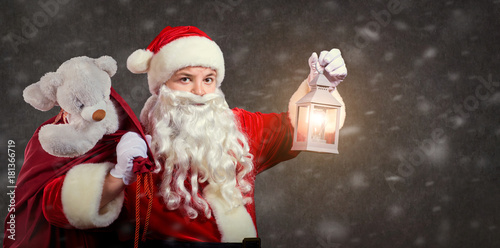 Santa Claus with a bag and a lamp on a Christmas.