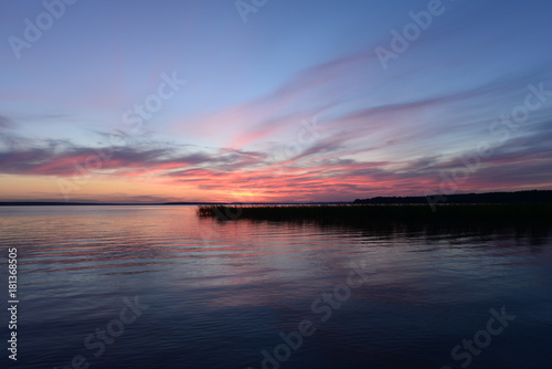 Nightfall twilight light glows in the sky above the lake © yarvin13