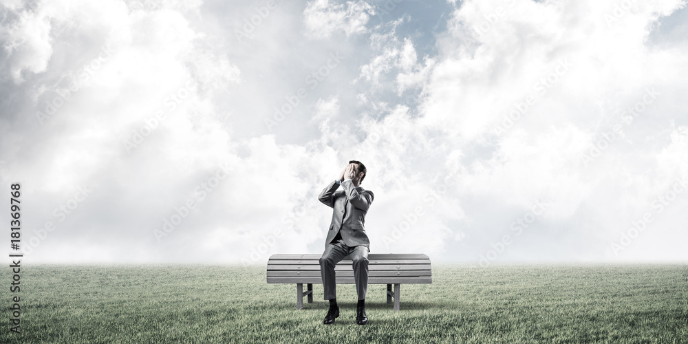 Young man in summer park on bench do not want to see anything Young man in summer park on bench do not want to see anything