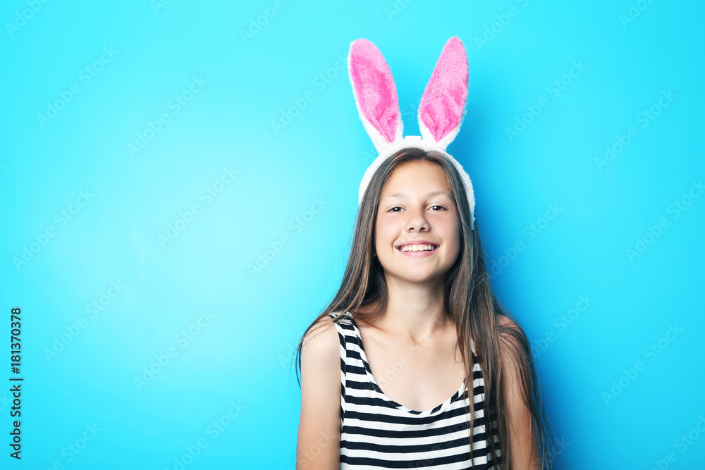 Portrait of beautiful girl with rabbit ears on blue background
