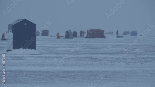 Ice huts are set up and people are in the backgroung