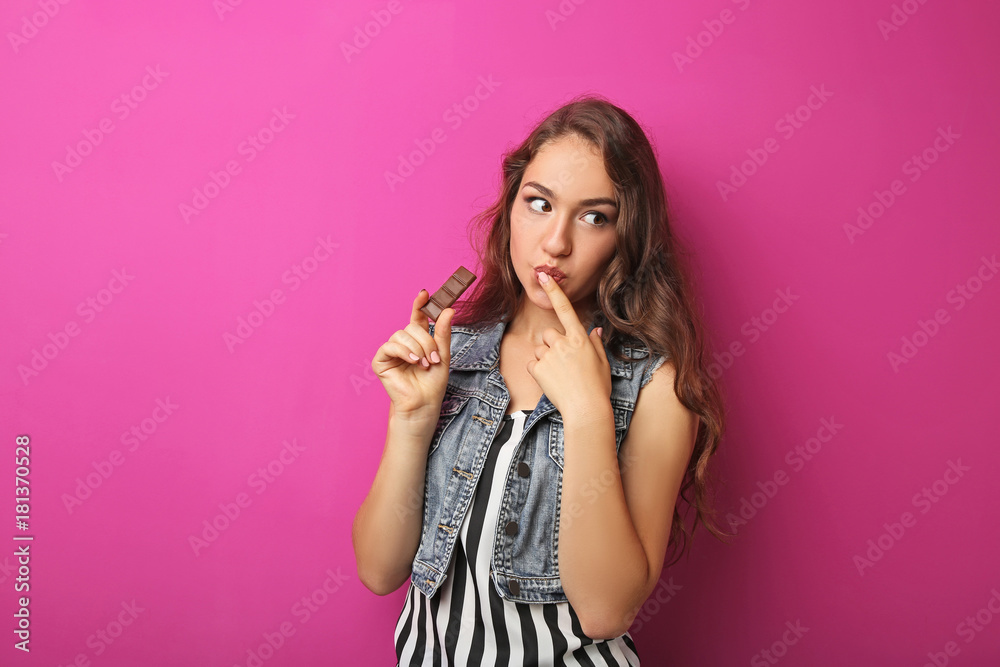 Portrait of young woman with chocolate on pink background Portrait of young woman with chocolate on pink background