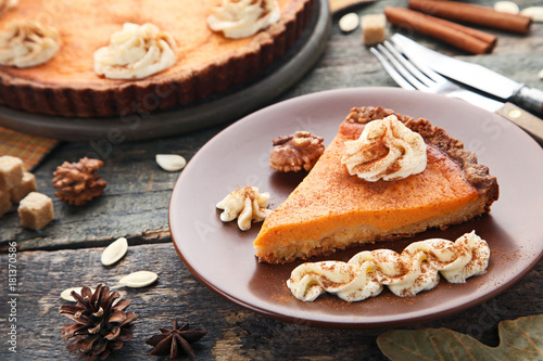 Sweet piece of pumpkin tart in plate on wooden table