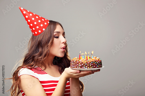 Photography Young woman blowing out candles on birthday cake