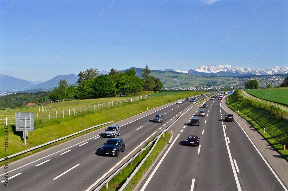 A3 - Autobahn mehrspurig zwischen Zürich und Chur. Autos beim fahren, Im Hintergrund Schweizer Schneeberge, A3 - Autobahn mehrspurig zwischen Zürich und Chur. Autos beim fahren, Im Hintergrund Schweizer Schneeberge,