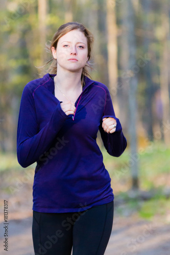 Fototapeta Naklejka Na Ścianę i Meble -  Female runner athlete running on forest trail.