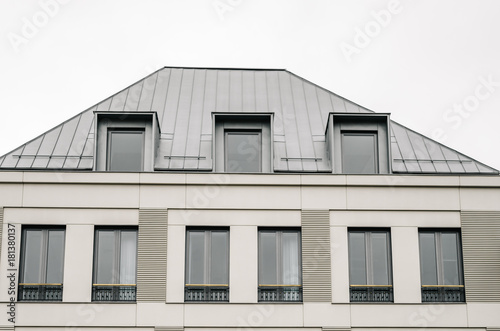 Front on new Modern house gray facade against cloudy sky, symmetry © LukeS