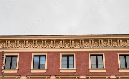 Ornamental facade of old history building, tenement on Old Town cloudy sky, copy space, symmetry