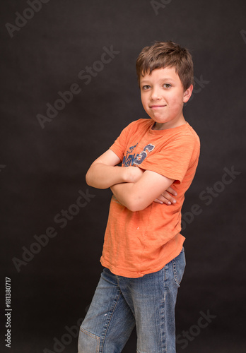 A boy portrait, young little cute and adorable kid, little obstreperous scamp. Poses, face expressions, ease, having fun, black background. photo