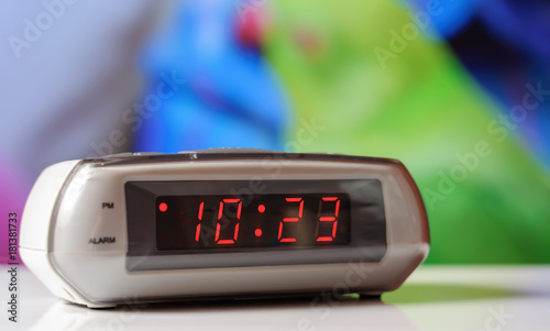 White electronic clock with a red dial. White clock with an alarm clock