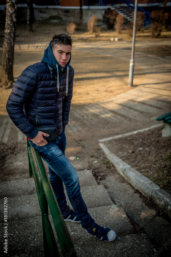 Attractive young man in the park leaning on handrail Attractive young man in the park leaning on handrail