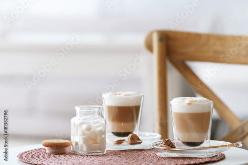 Tableau sur toile Glasses with latte macchiato on table indoors