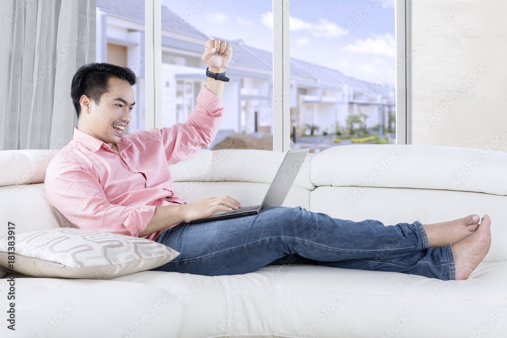 Fototapeta premium Success man with laptop on sofa