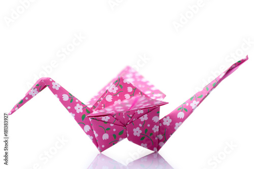 Pink orizuru figurine on white. Classic Japanese design of paper crane. Origami crafting, art lessons, culture.