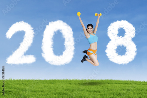 Sporty woman jumping with numbers 2018