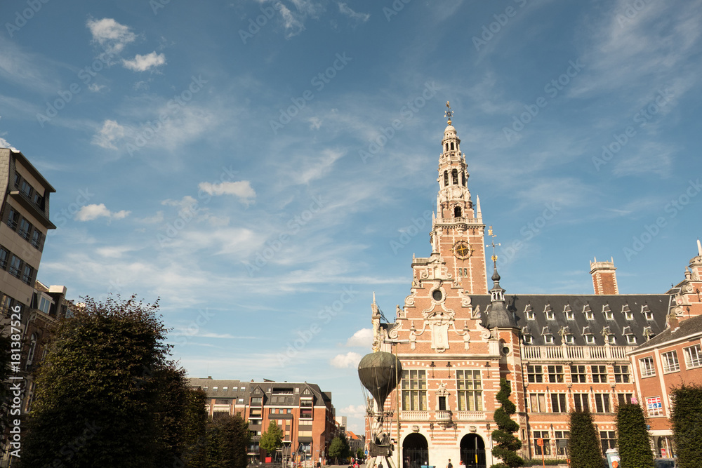 Students and tourists walk passed the Library at the Catholic University of Leuven (Universiteitsbibliotheek) on a sunny summer day.
