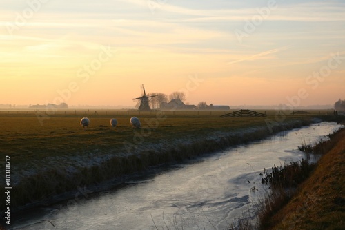Molen bij zonsondergang op het platteland photo